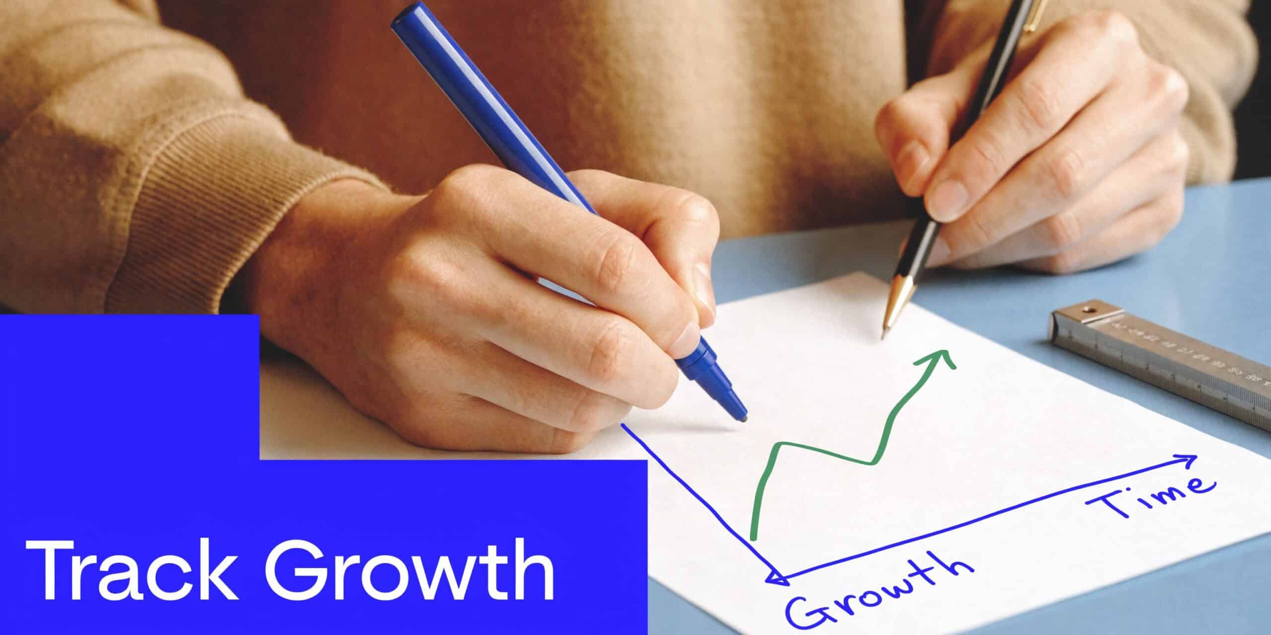 A person drawing a positive growth chart on a piece of paper to track business success.