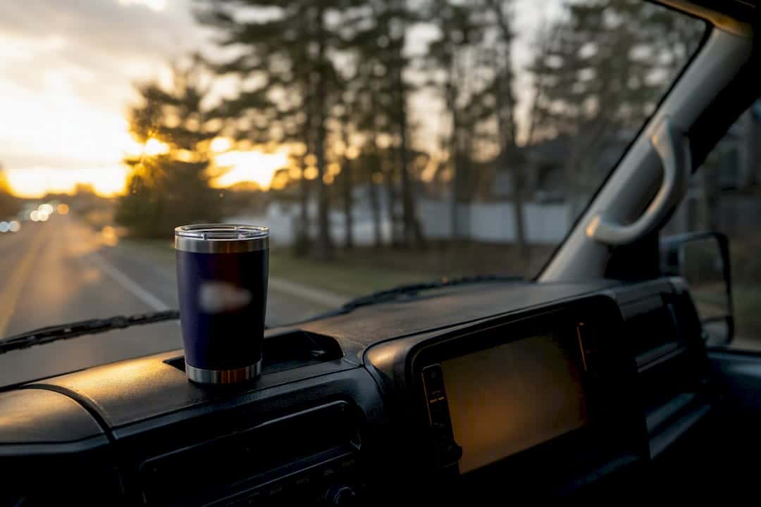 Insulated tumbler on dashboard of a work truck