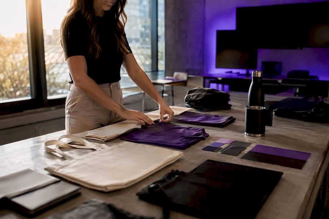 Hands arranging promotional merchandise items on table