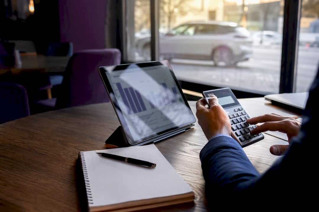 Hands calculating SEO budget with tablet graphs
